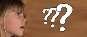 Young girl looking at question marks